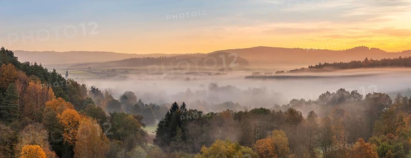 Landscape in Franconian Switzerland in autumn, view over colourful forests with morning mist at sunrise, Ahorntal, Franconian Switzerland, Upper Franconia, Bavaria, Germany