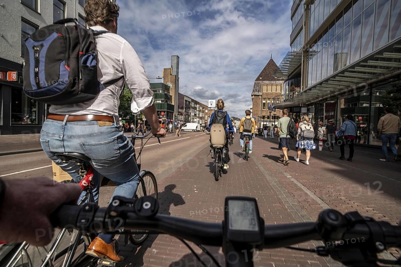 Ride your bike on the central cycle path on Lange Viestraat, Vredenburg, in the city centre of Utrecht, lanes for pedestrians, cyclists and public transport vehicles are separated, heavy cycle traffic, Netherlands