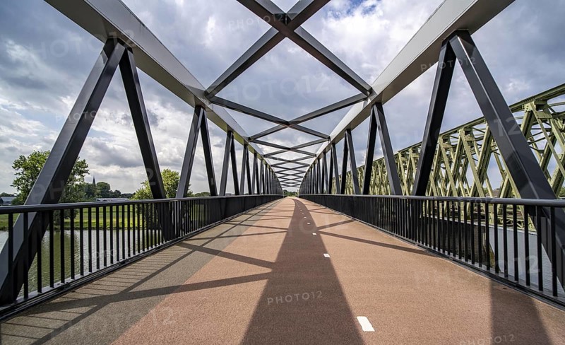 Ride over the De Massover cycle path bridge, over the Meuse south of Nijmegen, near Cuijk, part of the MaasWaalpad long-distance cycle path, 12 km between Nijmegen and Cuijk, built in 2021, for 15 million euros, Meuse river crossing for cyclists and pedestrians, part of a cycle path network, used by many commuters, next to a railway bridge, Netherlands