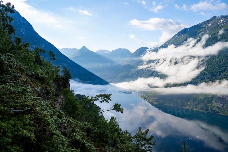 View over the Geirangerfjord, atmospheric clouds over the fjord in the morning light, Ørnesvingen viewpoint, near Geiranger, Møre og Romsdal, Norway