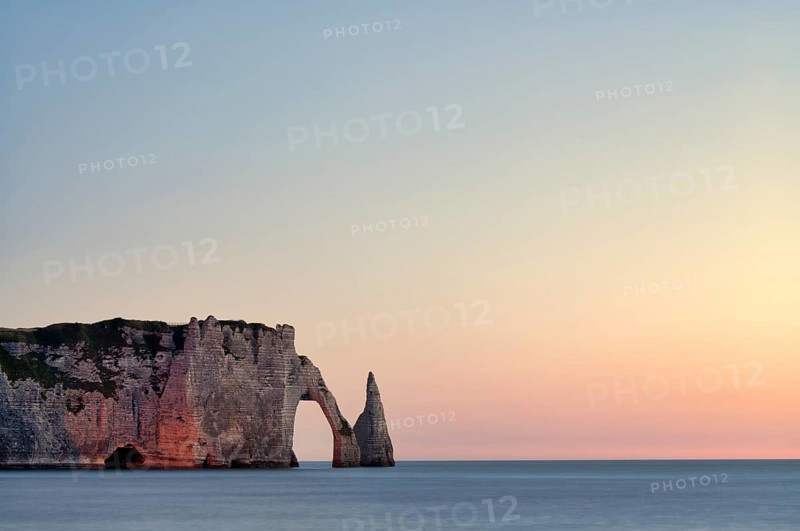 Rock arch Falaise or Porte d'Aval and rock needle Aiguille, illuminated, illuminated, Étretat, sea, steep coast, cliffs, chalk cliffs, alabaster coast, La Côte d'Albâtre, sunset, evening mood, atmospheric, Normandy, Seine-Maritime, France
