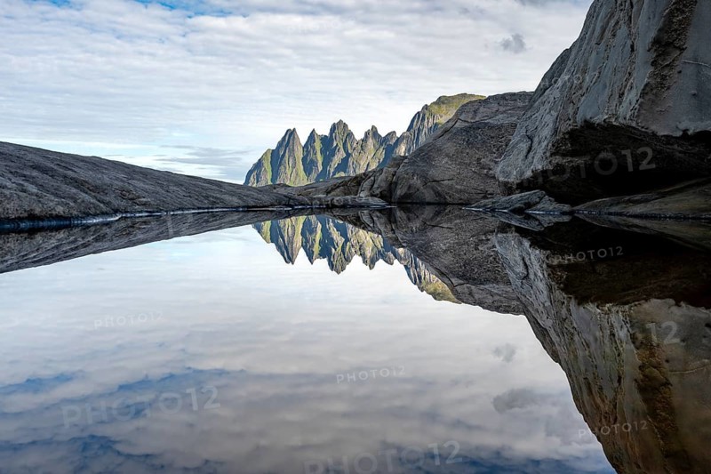 Reflection in a tidal pool, rocky coast of Tungeneset, Devil's Teeth, Okshornan, Ersfjorden, Senja Island, Troms, Norway