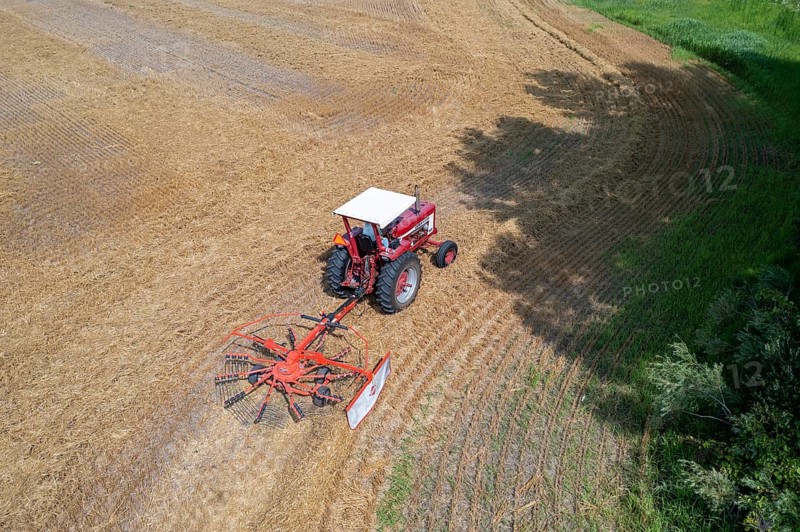 Wayland, Michigan - A farmer uses a rotary tedder to aerate his crop. A tedder spreads out hay or straw to allow quicker drying before baling