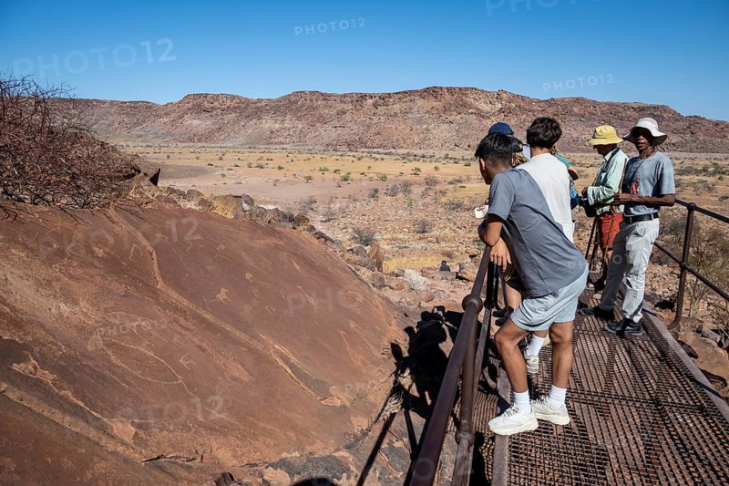 Tourists with guide at the rock engravings of Twyfelfontein, Twyfelfontein, Kunene, Namibia