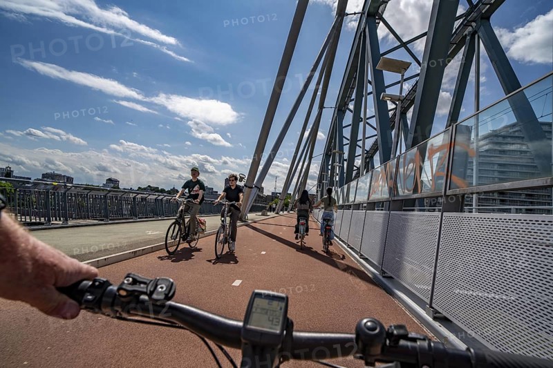 Ride over the Snelbinder Brug bicycle and pedestrian bridge, over the river Waal near Nijmegen, was built on the existing railway bridge, fast cycle path connection from the city centre of Nijmegen and the new housing estates in the Waalsprong district, Netherlands