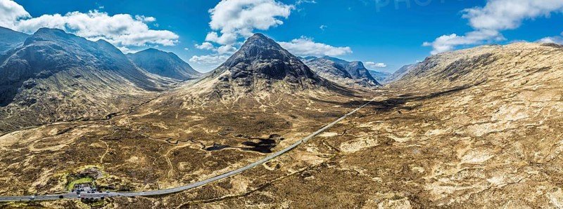 Panorama of Buachaille Etive Beag and Three Sisters in Glencoe over Moors and Road A82 from a drone, Highlands, Scotland, United Kingdom