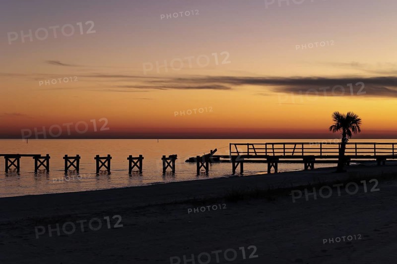 Sunset behind dilapidated fishing pier damaged by hurricanes on the Mississippi Gulf Coast in Long Beach, Mississippi
