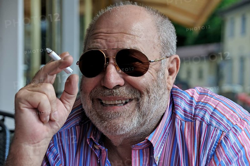 Portrait of a smiling elderly gentleman with a beard, sunglasses and a cigarette in his hand, Tegernbsee, Upper Bavaria, Germany
