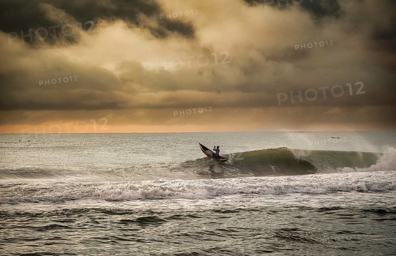 Fisherman in a traditional dugout canoe in the surf of the Indian Ocean on the east coast of Madagascar