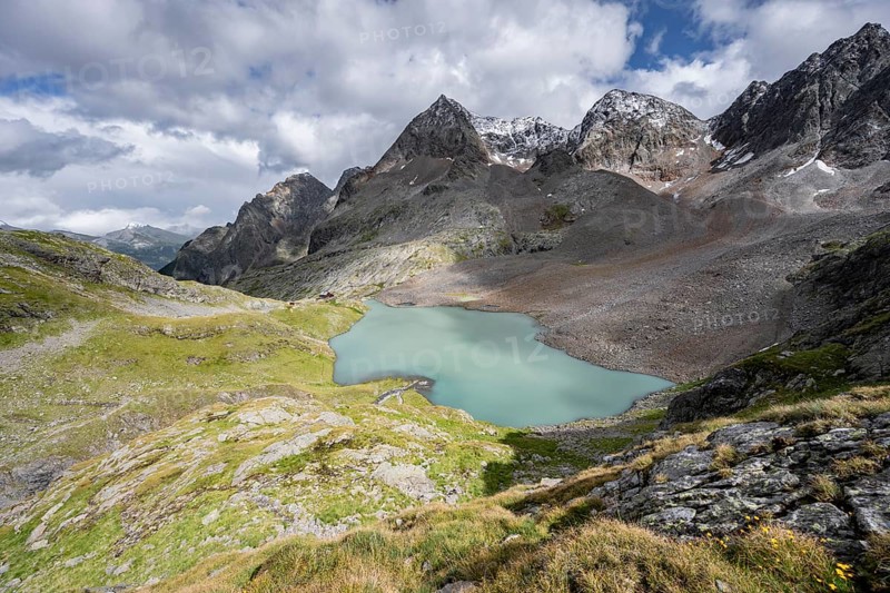 View of the turquoise-blue mountain lake Großer Gradensee, with the peaks of Petzeck and Kruckelkopf behind, Schober Group, Hohe Tauern National Park, Carinthia, Austria