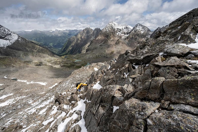 Mountaineer in rocky mountain landscape, descent from the summit of Keeskopf, behind summit of Petzeck, Hoher Perschitzkopf and Kruckelkopf, Schober group, Hohe Tauern National Park, Carinthia, Austria