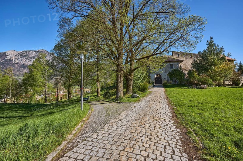 Castle Gruttenstein, mountains, footpath, cobblestones, entrance, trees, lawn, blue sky, cloudless, Pfannhauserweg, Bad Reichenhall, district Berchtesgadener Land, Bavaria, Germany