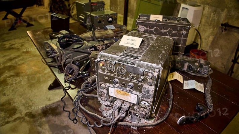 A pile of antique radios on a dark wooden table in a bunker, War Museum, Military Museum, Tunnel Museum, Lakki, Leros, WW2, Dodecanese, Greek Islands, Greece