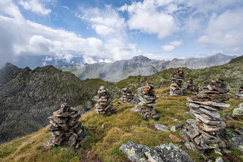 Cairn in mountain landscape, Kreuzseeschartl, cloudy mountain peaks, Schober group, Hohe Tauern National Park, Carinthia, Austria