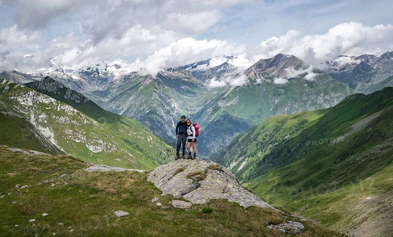 Two friends, mountaineers on a rock at the Mittagskögele, view of mountain peaks of the Venediger group and the Lasnitzental, Lasörling Höhenweg, Lasörling group, Hohe Tauern National Park, East Tyrol, Tyrol, Austria