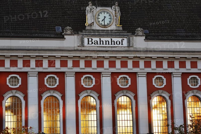 Hamm main station, façade with station clock and sculptures of a wire-drawer and a miner at the station building, North Rhine-Westphalia, Germany