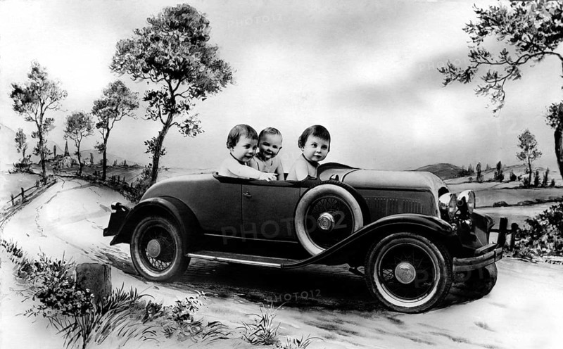 Three babies in a car, 1920s, Three children in a vintage car on a rural road, surrounded by trees, Historical photo