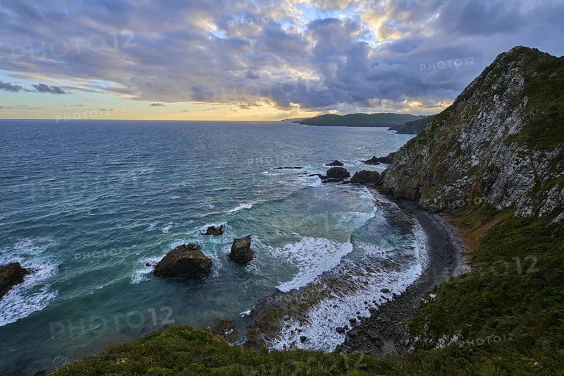 Dramatic coastline with high cliffs and stormy waves, summer, Nugget Point lighthouse, Ahuriri Flat, Otago, South Island, New Zealand