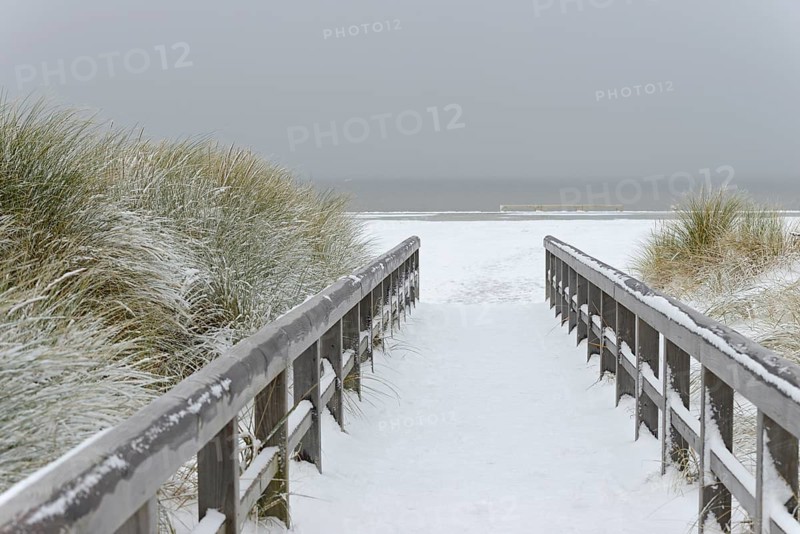 Winter day, onset of winter, wooden plank path leads through the snow-covered dune landscape to the North Sea, Norddeich, Lower Saxony, Germany