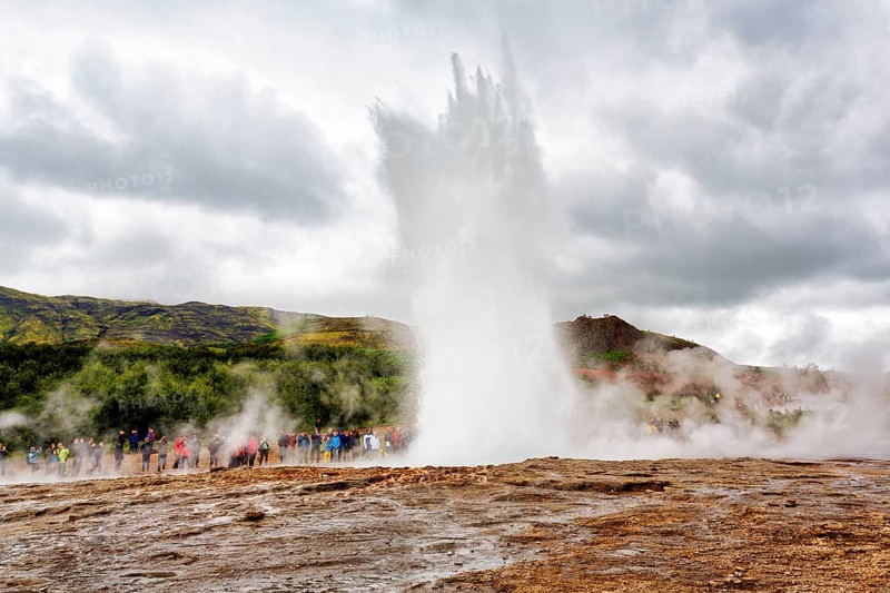 Active Strokkur, tourists observe eruption, high temperature area Haukadalur, tourist attraction at the Golden Circle, Sudurland, Iceland