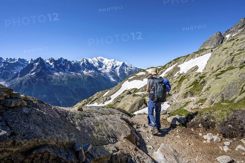 Mountaineer on hiking trail, mountain panorama with glaciated mountain peaks, Aiguille du Midi and Mont Blanc, Aiguille de Mesure and Aiguille de Chamois, Aiguilles Rouges, Chamonix, Haute-Savoie, France