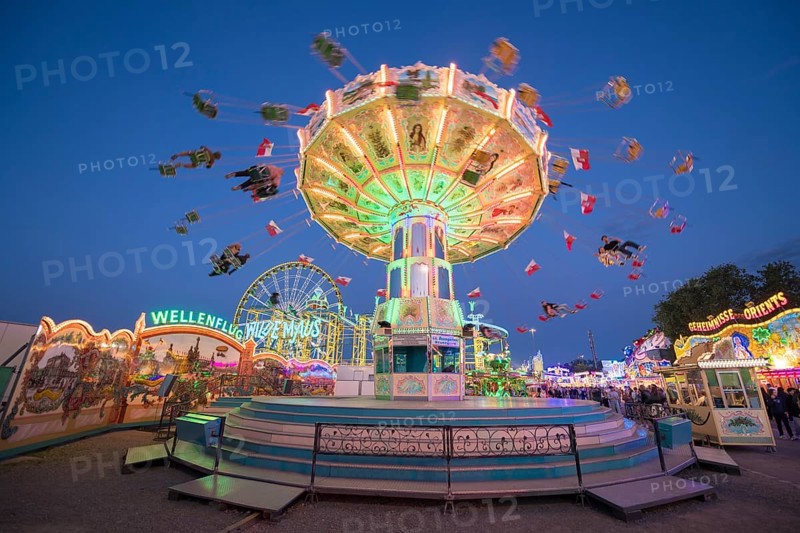 Colourful carousel with light show at a funfair at night, chain carousel, spring festival, Cannstatter Wellenflug, illuminated, blue hour, Cannstatter Wasen, Bad Cannstatt, Stuttgart, Baden-Württemberg, Germany