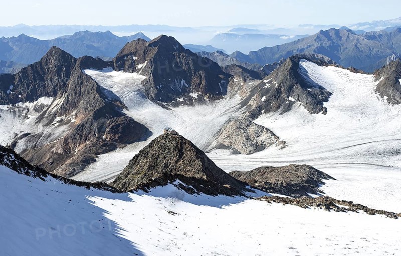 At the Wilder Freiger summit, picturesque high mountain landscape with snow, view of the Übeltalferner glacier and rocky mountain peaks Becher with Becherhaus and Königshofspitz, Stubai Alps, South Tyrol, Italy