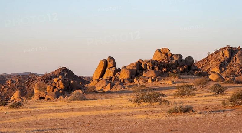 Barren landscape with hills of stacked rocks, desert landscape in the evening light at sunset, Erongo, Damaraland, Namibia