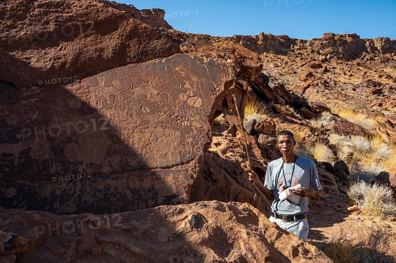 Tourist guide explains the details of the rock engravings at Twyfelfontein, Twyfelfontein, Kunene, Namibia