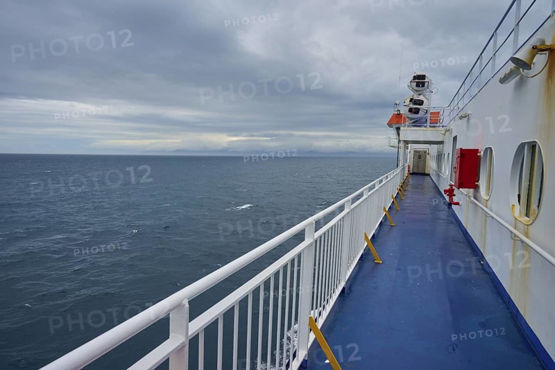 View over the deck of a ferry to the wide sea under a cloudy sky, summer, Cook Strait, North Island, South Island, New Zealand