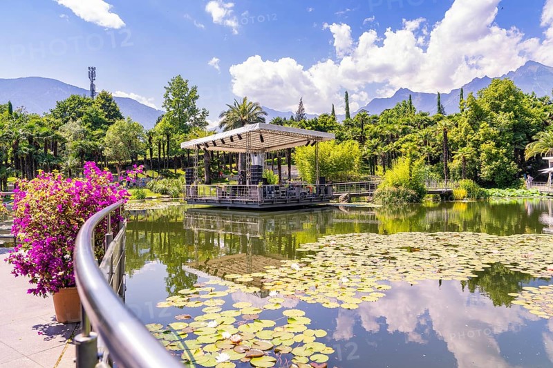 Idyllic park with pond, pavilion and mountains in the background, Botanical Garden, The Gardens of Trauttmansdorff Castle, Merano, South Tyrol, Italy