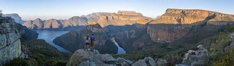 Two hikers enjoying the panorama, sunset at Blyde River Canyon with Three Rondawels peak, view of canyon with Blyde River and table mountains in the evening light, canyon landscape, Panorama Route, Mpumalanga, South Africa