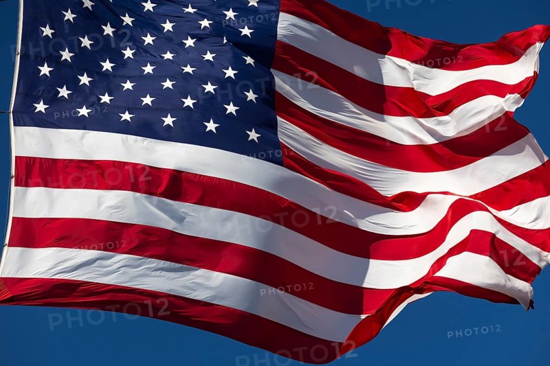 American flag waving in the wind against deep blue sky