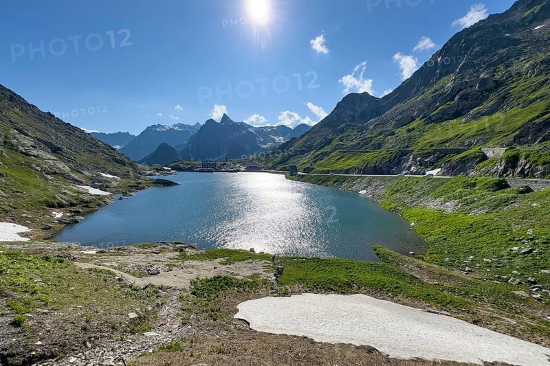 View from Swiss territory to Italian territory over mountain lake Lac du Grand Saint Bernard on top of pass road mountain pass alpine pass border pass Great St. Bernard Pass, pass road, mountain pass above tree line early summer, tree line, Great St. Bernard Pass, Valais, Switzerland, Valle d'Aosta region, Italy