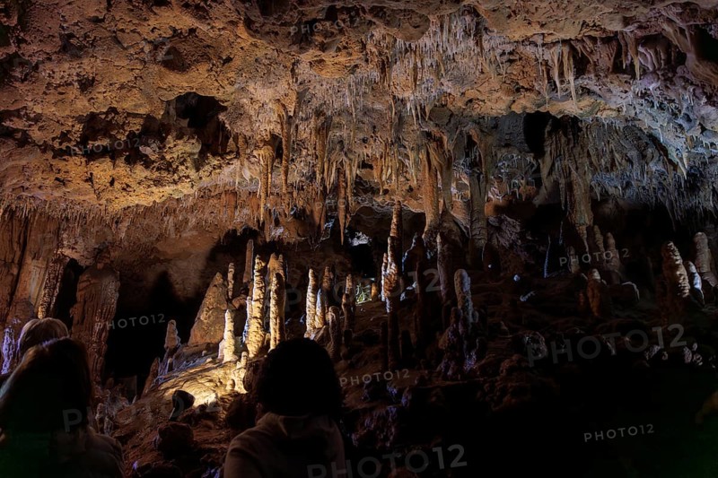 Tourists walking past limestone rock formations in a cave at Florida Caverns State Park in the Florida panhandle near Marianna
