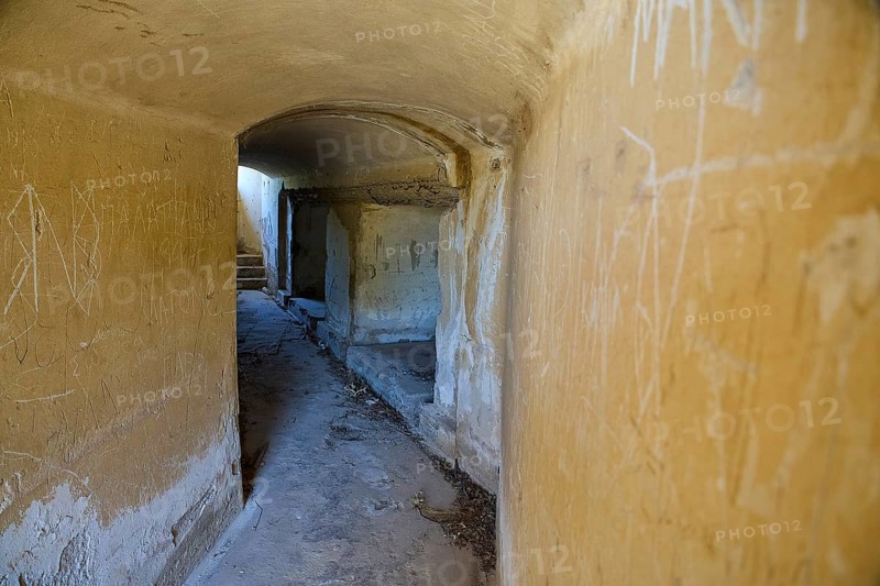 Long corridor with weathered walls leading into the darkness, mysterious and abandoned, Italian anti-aircraft position, ground defence position, PL306 with 6 cannons, WW2, Vigla Mountain, Vigla, above Lakki, Lakki, Leros, Dodecanese, Girechian Islands, Greece