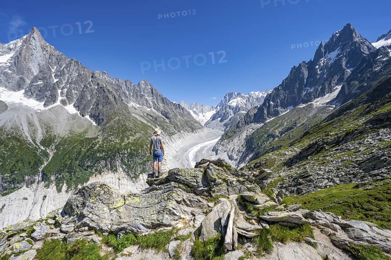 Picturesque mountain landscape with imposing mountain peaks and glaciers, mountaineer on hiking trail, Grand Balcon Nord, glacier tongue Mer de Glace, behind Grandes Jorasses, Mont Blanc massif, Montenvers, Chamonix, Haute-Savoie, France