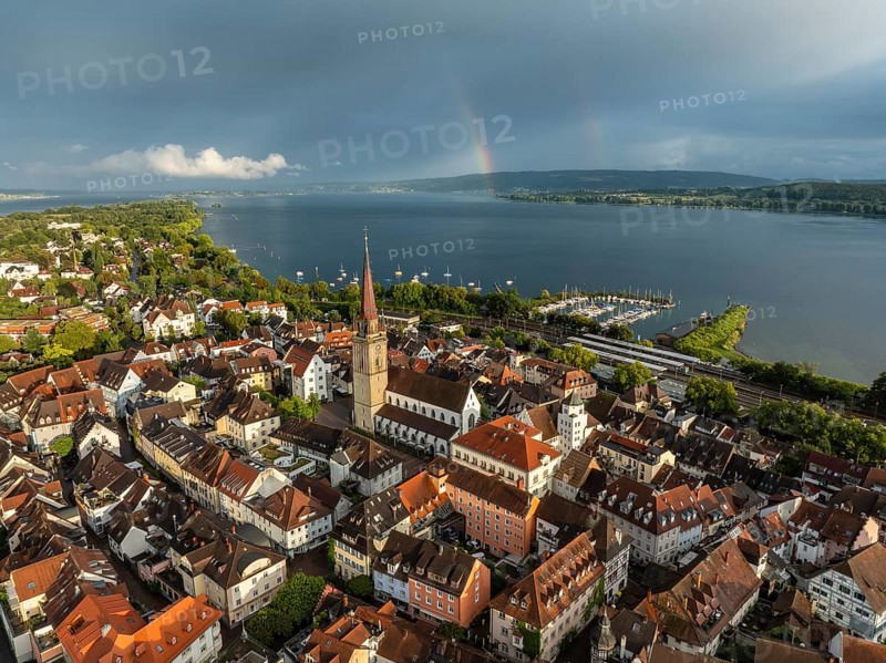 Luftbild von der Stadt Radolfzell am Bodensee mit der historischen Altstadt und dem Radolfzeller Münster nach einem Gewitterschauer von der Abendsonne angestrahlt, am Horizont ein Regenbogen, Landkreis Konstanz, Baden-Württemberg, Deutschland