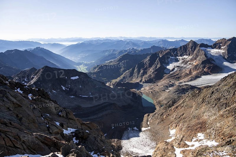 View of mountain panorama into the Ridnaun valley with blue glacier lake, ascent to the Wilder Freiger, Stubai Alps, South Tyrol, Italy