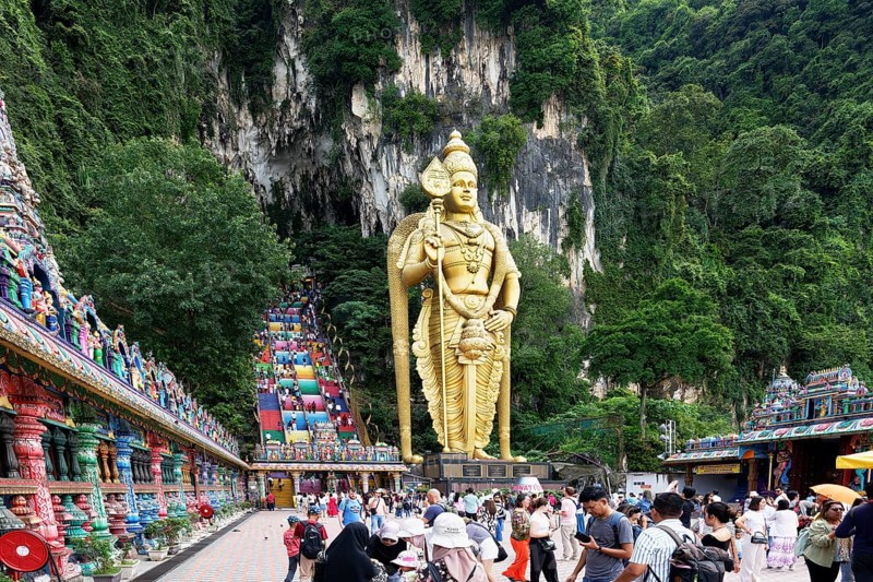 Murugan statue the God of War and colorful staircase leading to the caves with many pilgrims, Batu Caves complex, Kuala Lumpur, Malaysia, Asia