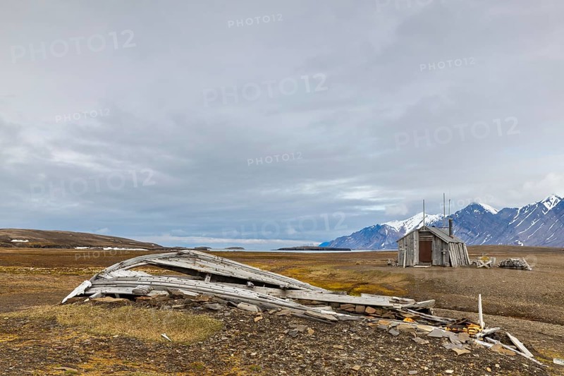 Broken wooden boat in front of hunting hut, wooden hut, Bamsebu, Spitsbergen, Svalbard