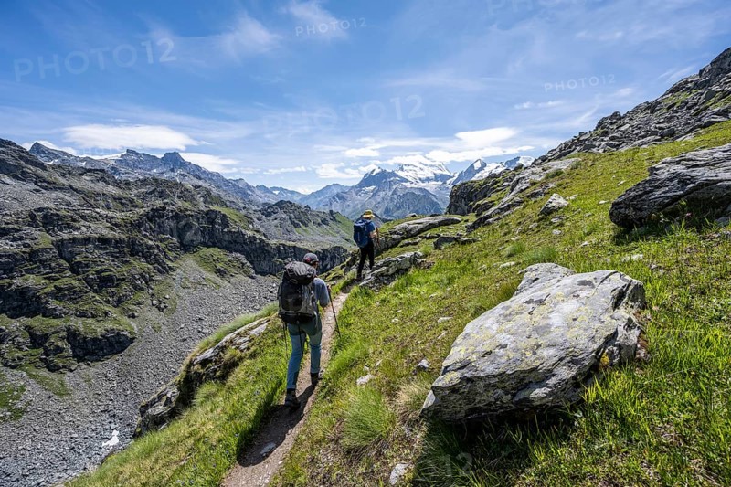 Mountaineer on hiking trail in mountain landscape, descent at Col du Louvie, view of the summit of the Grand Combine, Valais Alps, Val de Bagnes, Valais, Switzerland