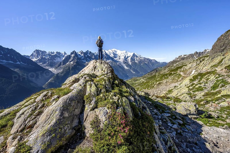 Mountaineer on a rock, mountain panorama with glaciated mountain peaks, Aiguille du Midi and Mont Blanc, Aiguille de Mesure and Aiguille de Chamois, Aiguilles Rouges, Chamonix, Haute-Savoie, France