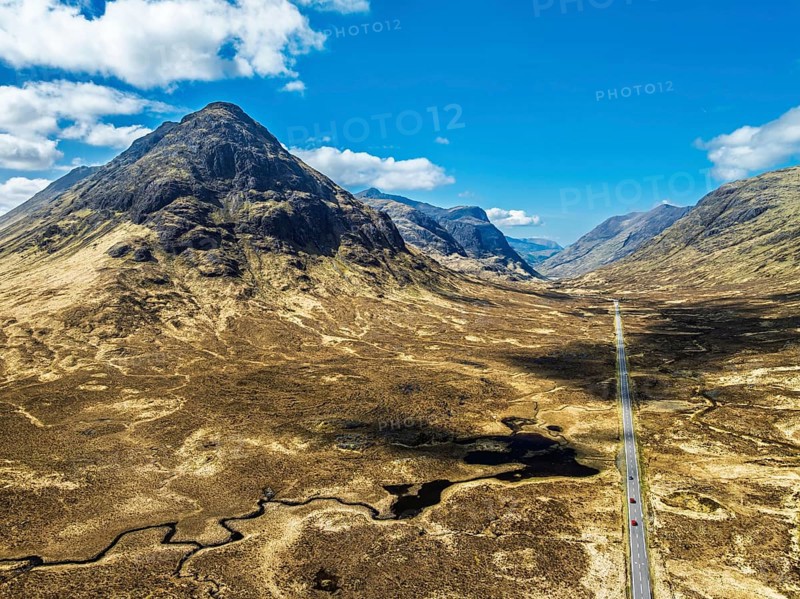 Buachaille Etive Beag and Three Sisters in Glencoe over Moors and Road A82 from a drone, Highlands, Scotland, United Kingdom