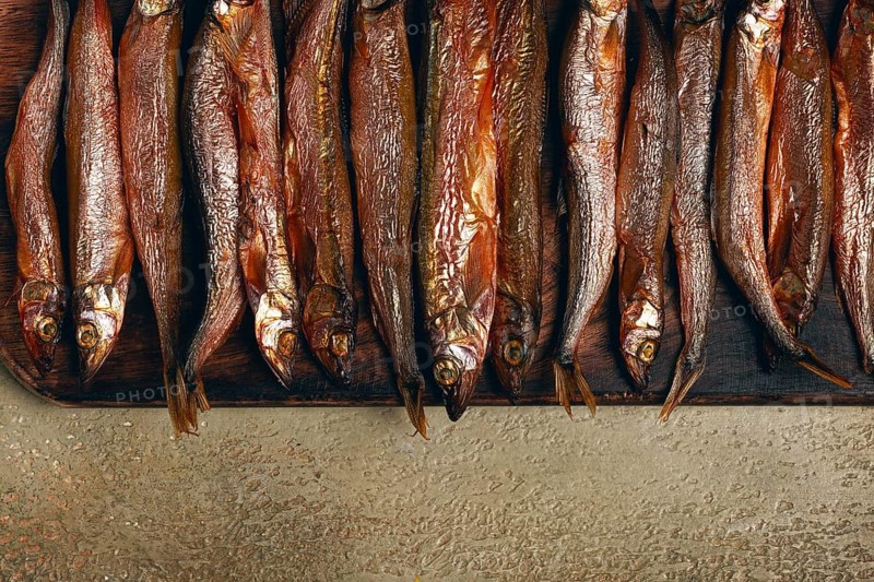 Cold smoked capelin, on a wooden chopping board, no people