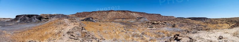 Dry landscape with yellow grass and black volcanic hills, Burnt Mountain, Damaraland, Kunene, Namibia