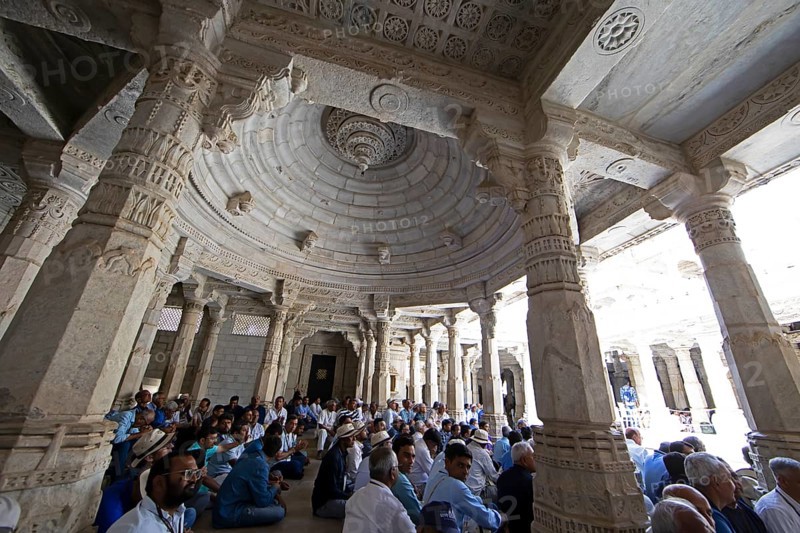 Indian men praying between the white marble pillars in the Adinath temple in Ranakpur, Jain temple, Rajasthan, India