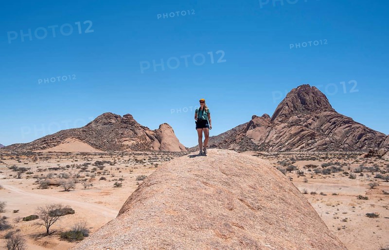 Tourist with camera, rock formation, Pontok Mountains, Spitzkoppe, Große Spitzkuppe Nature Reserve, Namibia