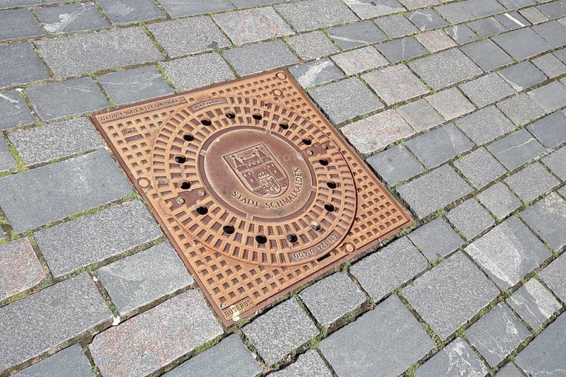 Square manhole cover with town coat of arms and inscription, paving stones, floor, Schmalkalden, Franconia, Thuringia, Germany