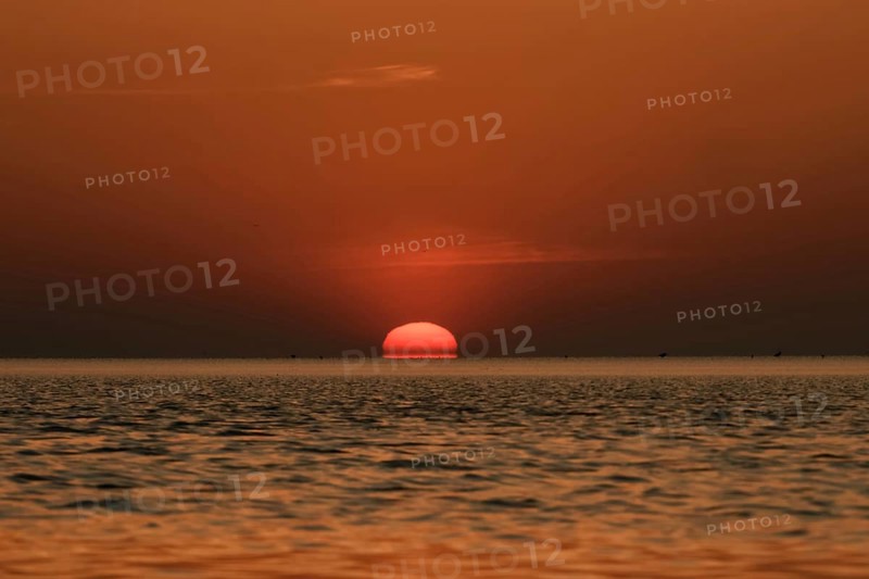 When the red sun sinks into the sea... Cuxhaven, North Sea, sunset in calm weather, glowing red fireball, sun sets fiery red over the sea, sinks into the sea, atmospheric picture, local nature, Lower Saxony Wadden Sea National Park, North Sea near Cuxhaven, Duhnen, Lower Saxony, Germany, Western Europe